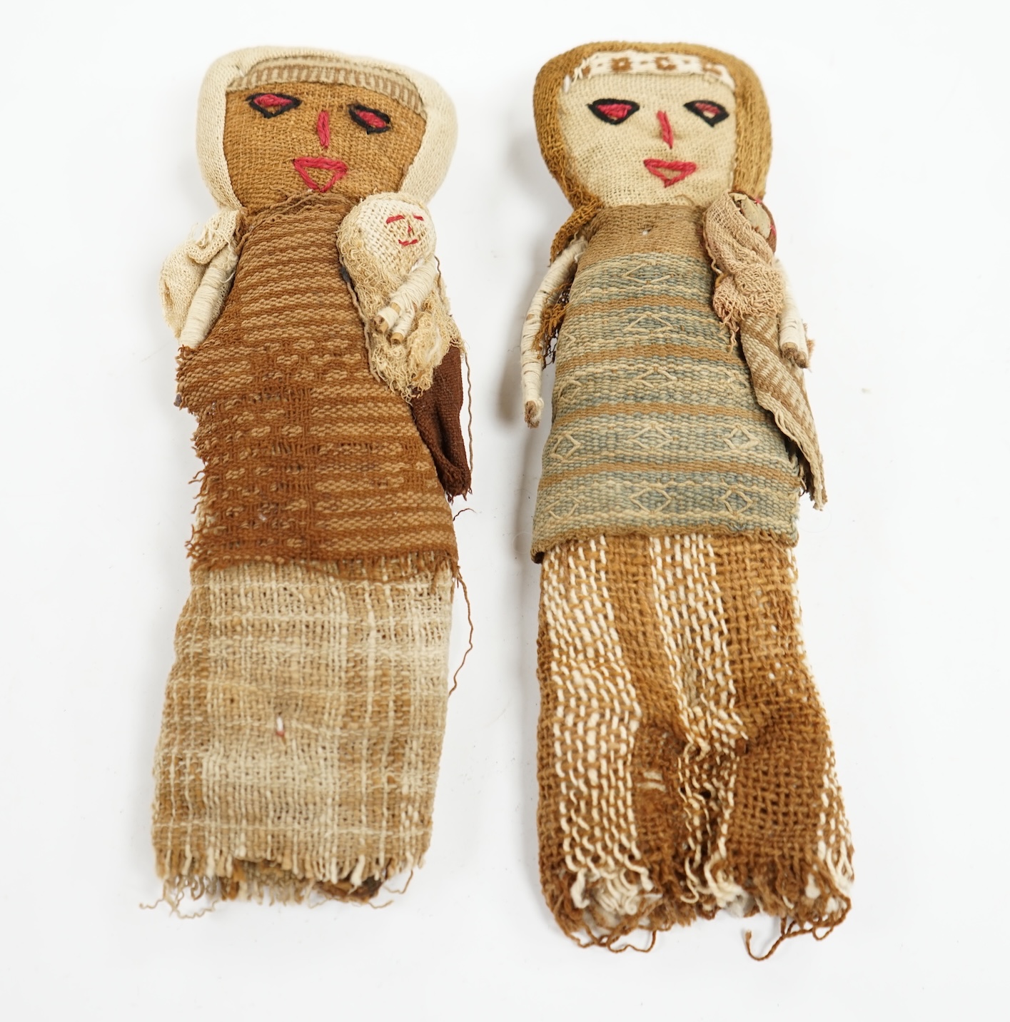 Two antique Chancay culture, central Peruvian hand made fabric dolls each carrying a baby. 25cm high. Condition - fair